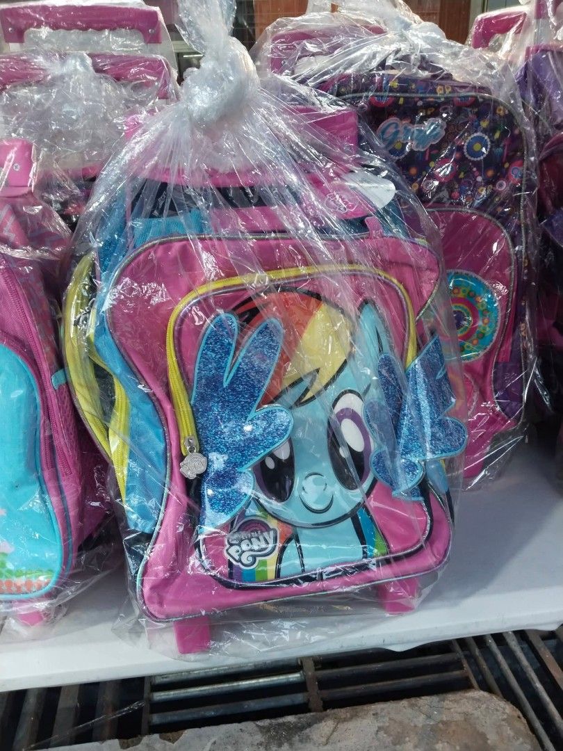 Mall Pullout Little Pony Rainbow Trolley Bag (Category: Backpacks) located in Quezon City. Submitted by mharia_elha (Listing ID 1441414271, Image 1). Description: - Adorable My Little Pony rolling backpack featuring Rainbow Dash. - Sparkly glittery wings add a magical touch. - Eye-catching pink and blue design. - Equipped with wheels and a retractable handle for easy portability. - Perfect for school, day trips, or travel adventures. - Brand new 