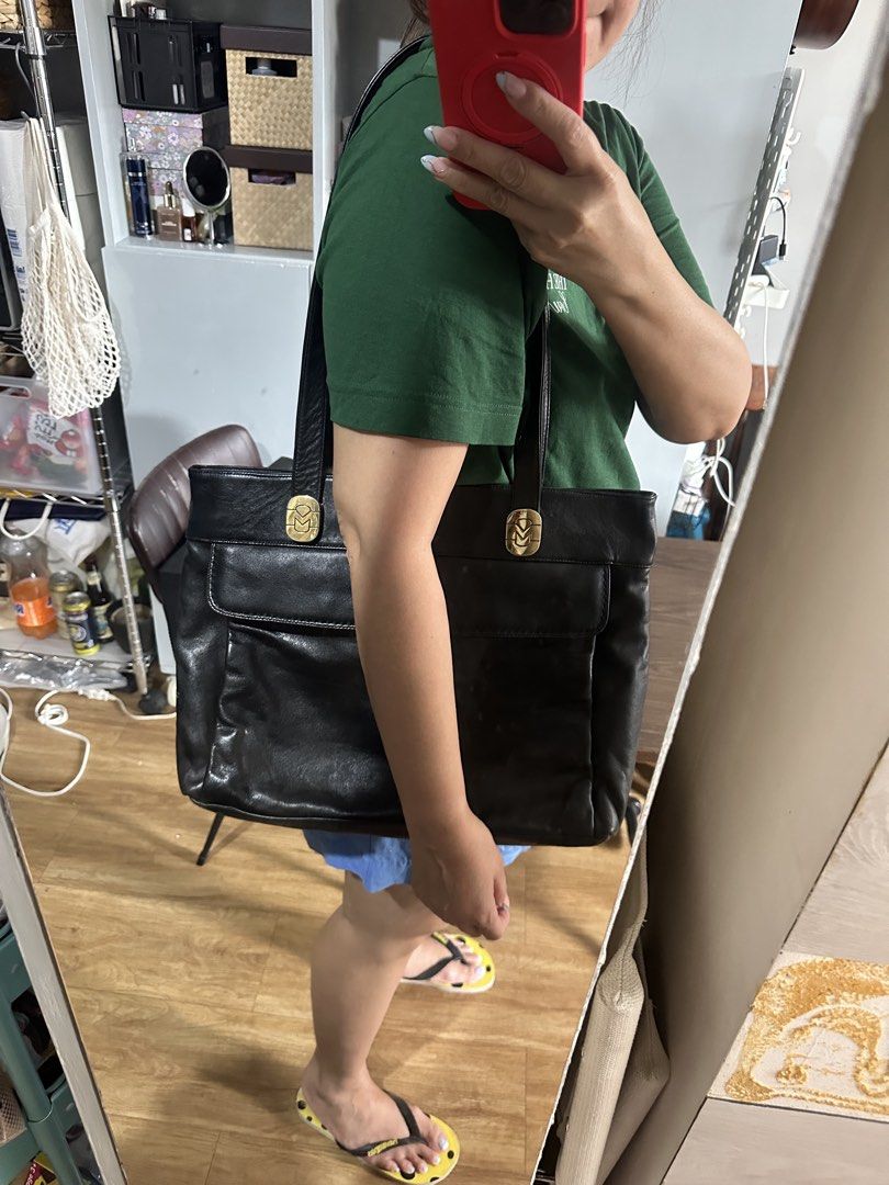 Marina D. Black Leather Tote Bag (Category: Tote Bags) located in Paranaque City. Submitted by charlottie72 (Listing ID 1441509399, Image 3). Description: - Classic black leather tote bag - Gold-tone hardware with Marina D. logo - Zippered top closure - Convenient exterior pocket - Interior lining features brand name - Spacious design for essentials - Ideal for everyday use or work.