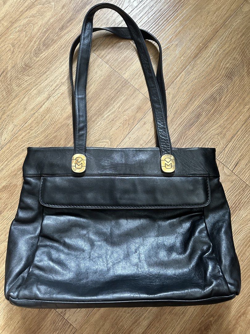 Marina D. Black Leather Tote Bag (Category: Tote Bags) located in Paranaque City. Submitted by charlottie72 (Listing ID 1441509399, Image 1). Description: - Classic black leather tote bag - Gold-tone hardware with Marina D. logo - Zippered top closure - Convenient exterior pocket - Interior lining features brand name - Spacious design for essentials - Ideal for everyday use or work.