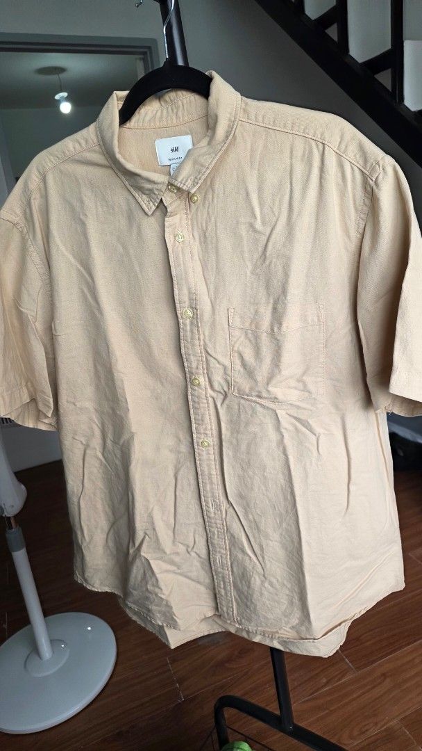 Men's Short Sleeve Button-Up Shirt (Category: Tshirts & Polo Shirts ) located in Mandaluyong City. Submitted by deverarose (Listing ID 1441388457, Image 1). Description: - Light beige short sleeve button-up shirt - Classic collar with button closure - One chest pocket - Comfortable, casual fit - Great for everyday wear or layering - Easy to pair with various outfits.