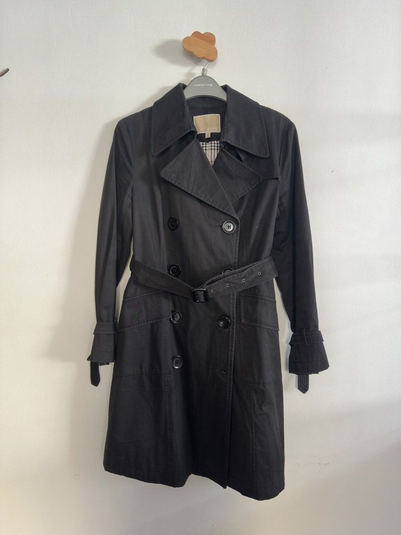 Michael Kors Black Double Breasted Trench Coat (Category: Coats, Jackets and Outerwear) located in Quezon City. Submitted by arlenemabazza (Listing ID 1441472310, Image 1). Description: - Classic black trench coat by Michael Kors - Double-breasted design with a belted waist - Signature plaid lining inside - Versatile for layering over any outfit - Timeless and sharp aesthetic.