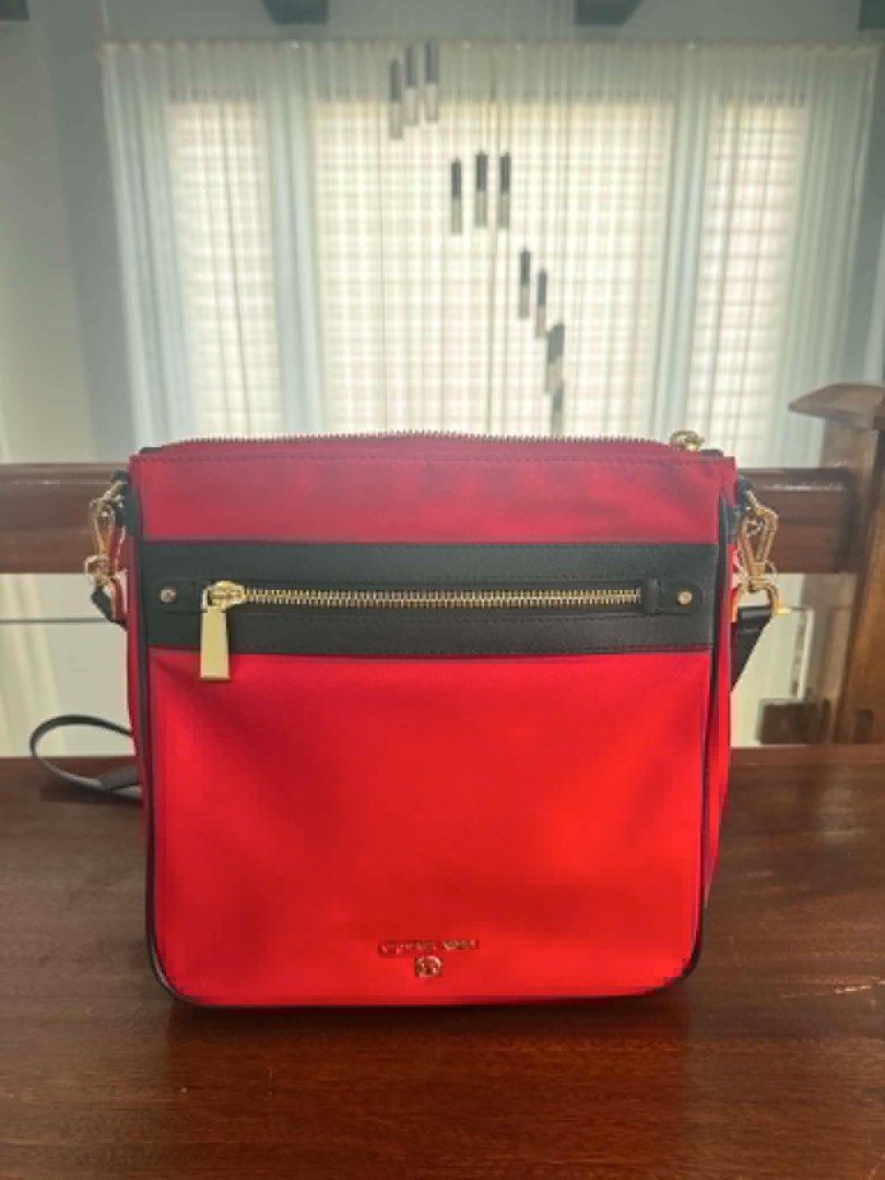 Michael Kors Red Nylon Crossbody Bag (Category: Cross-body Bags) located in Manila. Submitted by kobealvarez (Listing ID 1441481566, Image 3). Description: - Red Michael Kors crossbody bag - Black trim and gold hardware - Zip closure on front pocket and main compartment - Adjustable strap - Interior zip pocket and card slots - Ideal for everyday use - with tag 108$.