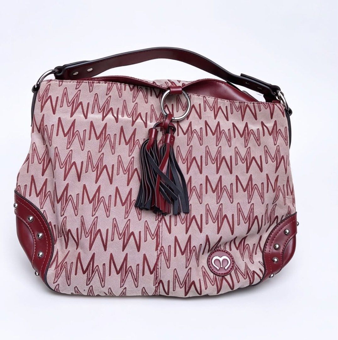 MICHAELA Signature Monogram Studded Hobo Shoulder Bag (Category: Shoulder Bags) located in Pasay City. Submitted by fromtheashes (Listing ID 1441472654, Image 2). Description: issue: leather peeling This is a medium-sized everyday hobo bag featuring MICHAELA’s signature repeating “M” monogram print in deep burgundy/maroon against a light neutral canvas base. It is accented with smooth vegan/faux leather trim on the handle, corners, and bottom, fi