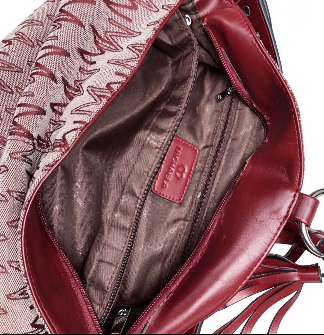 MICHAELA Signature Monogram Studded Hobo Shoulder Bag (Category: Shoulder Bags) located in Pasay City. Submitted by fromtheashes (Listing ID 1441472654, Image 3). Description: issue: leather peeling This is a medium-sized everyday hobo bag featuring MICHAELA’s signature repeating “M” monogram print in deep burgundy/maroon against a light neutral canvas base. It is accented with smooth vegan/faux leather trim on the handle, corners, and bottom, fi