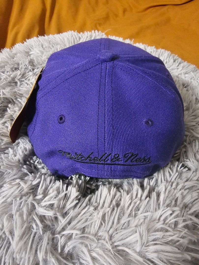 Mitchell & Ness Los Angeles Lakers NBA Finals Cap (Category: Caps & Hats) located in Trece Martires City. Submitted by haneinomichi (Listing ID 1441567096, Image 2). Description: - Brand: Mitchell & Ness - Team: Los Angeles Lakers - Edition: NBA Finals - Color: Purple with yellow embroidered 'Lakers' script -snake skin design sa brim -2009 pin - Ideal for: Lakers and Kobe fans.