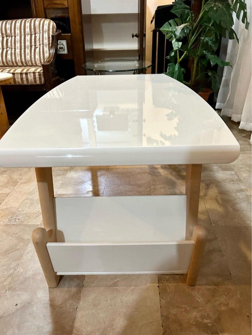 Modern White Center Table with Magazine Rack (Category: Tables & Sets) located in Bulacan. Submitted by nyesa21 (Listing ID 1441462626, Image 3). Description: - Modern white coffee table - Sturdy light wood legs - Convenient built-in magazine rack - Sleek, curved edges for a contemporary look - Easy-to-clean surface - Ideal size for living rooms and lounges - Perfect for everyday use.
