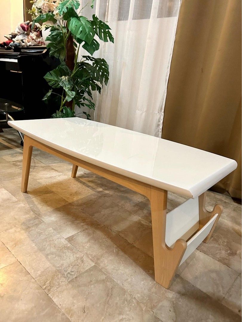 Modern White Center Table with Magazine Rack (Category: Tables & Sets) located in Bulacan. Submitted by nyesa21 (Listing ID 1441462626, Image 1). Description: - Modern white coffee table - Sturdy light wood legs - Convenient built-in magazine rack - Sleek, curved edges for a contemporary look - Easy-to-clean surface - Ideal size for living rooms and lounges - Perfect for everyday use.