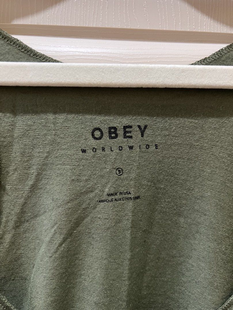 (OBEY Propaganda) "Think & Create" Light Olive Track Tank Top (S) (Category: Sleeveless) located in Angono. Submitted by elyenitty_ (Listing ID 1441515377, Image 2). Description: - OBEY Propaganda tank top - Color: Light olive - Features "Think & Create" graphic - Racerback style - Made in USA - Material: 50% Cotton, 50% Polyester - Ideal for casual wear.