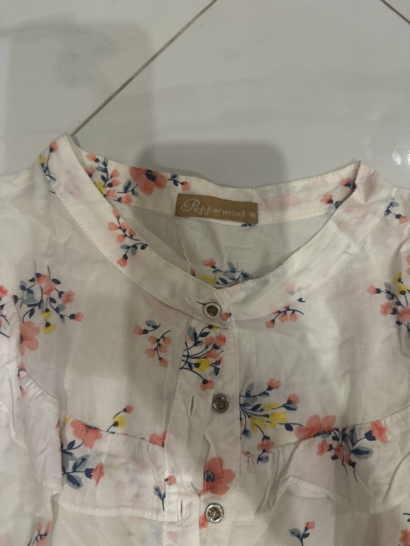 Peppermint White Floral Short Sleeve Button Up Blouse (Category: Blouses) located in Manila. Submitted by matchagirl333 (Listing ID 1441509346, Image 2). Description: - White short sleeve blouse - Pretty floral print - Mandarin collar - Button-up front - Lightweight and airy fabric - Versatile for casual or dressy occasions - Easy to pair with jeans or skirts.