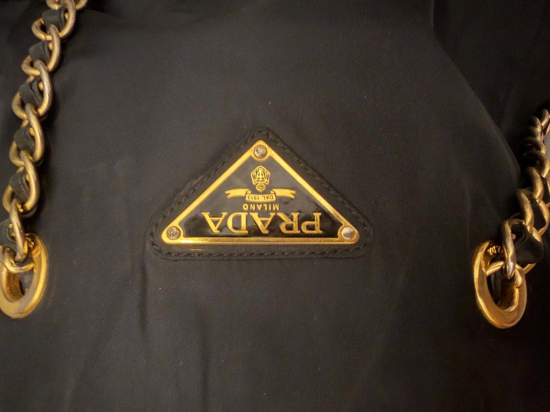 Prada Black Tessuto Nylon Chain Tote (Category: Luxury Bags & Wallets) located in Manila. Submitted by moiluxe (Listing ID 1441378510, Image 3). Description: This is a vintage Prada Black Tessuto Nylon Chain Tote bag, known for its gold-tone chain handles and iconic triangle logo. My facebook moi luxe verified badge you may mesaageme for more information.