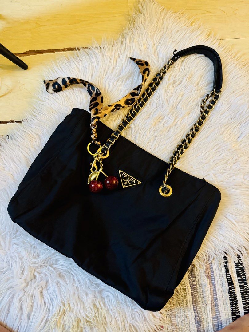 Prada Black Tessuto Nylon Chain Tote (Category: Luxury Bags & Wallets) located in Manila. Submitted by moiluxe (Listing ID 1441378510, Image 1). Description: This is a vintage Prada Black Tessuto Nylon Chain Tote bag, known for its gold-tone chain handles and iconic triangle logo. My facebook moi luxe verified badge you may mesaageme for more information.