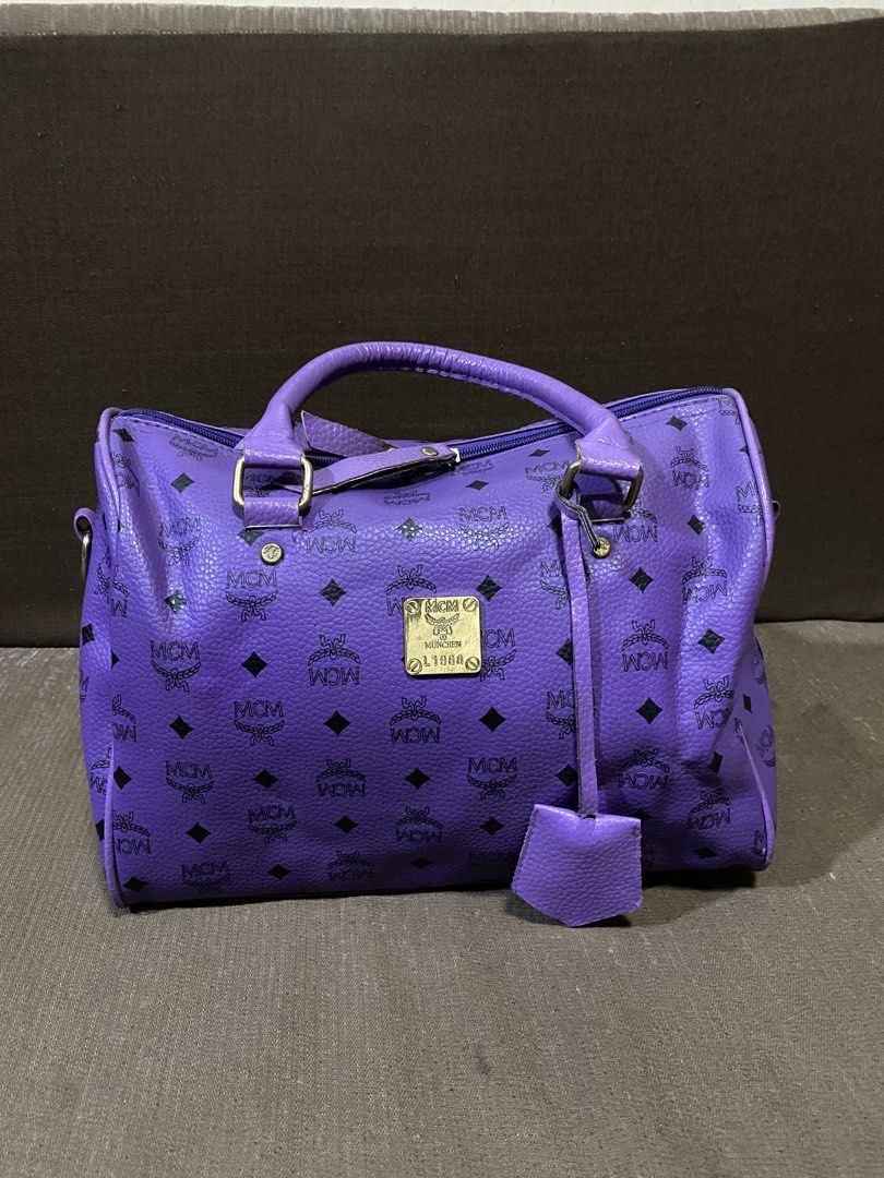 Purple MCM Monogram Boston Bag (Category: Luxury Bags & Wallets) located in San Antonio. Submitted by pixiechromzzz (Listing ID 1441516176, Image 2). Description: - purple MCM Boston bag - Signature monogram print - Gold-tone hardware and leather trim - Detachable shoulder strap included - Secure zipper closure - Ideal for everyday style and practicality - Approximate dimensions: 12"L x 6"W x 7"H.
