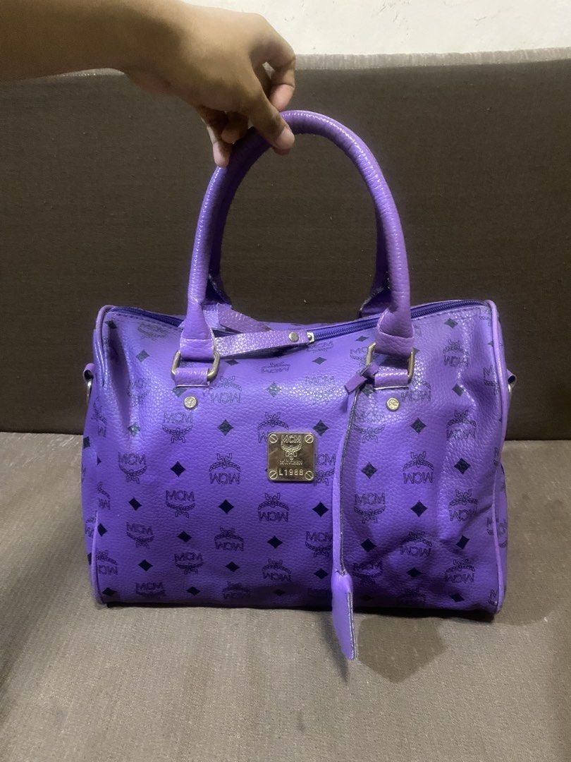 Purple MCM Monogram Boston Bag (Category: Luxury Bags & Wallets) located in San Antonio. Submitted by pixiechromzzz (Listing ID 1441516176, Image 1). Description: - purple MCM Boston bag - Signature monogram print - Gold-tone hardware and leather trim - Detachable shoulder strap included - Secure zipper closure - Ideal for everyday style and practicality - Approximate dimensions: 12"L x 6"W x 7"H.
