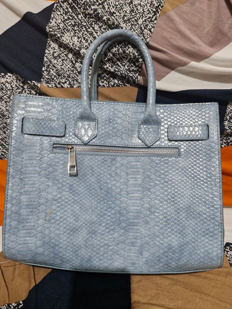 RICKI'S Light Blue Snakeskin Textured Handbag (Category: Tote Bags) located in Manila. Submitted by madam_q (Listing ID 1441420587, Image 2). Description: A gift lang din but di ako mahilig sa ganitong type ng bag.. - Light blue handbag with a stylish snakeskin texture. - Secure zip closure for your belongings. - Comfortable top handles for easy carrying. - Elegant silver hardware details. - Brand: RICKI'S - Ideal size for your daily essentials..