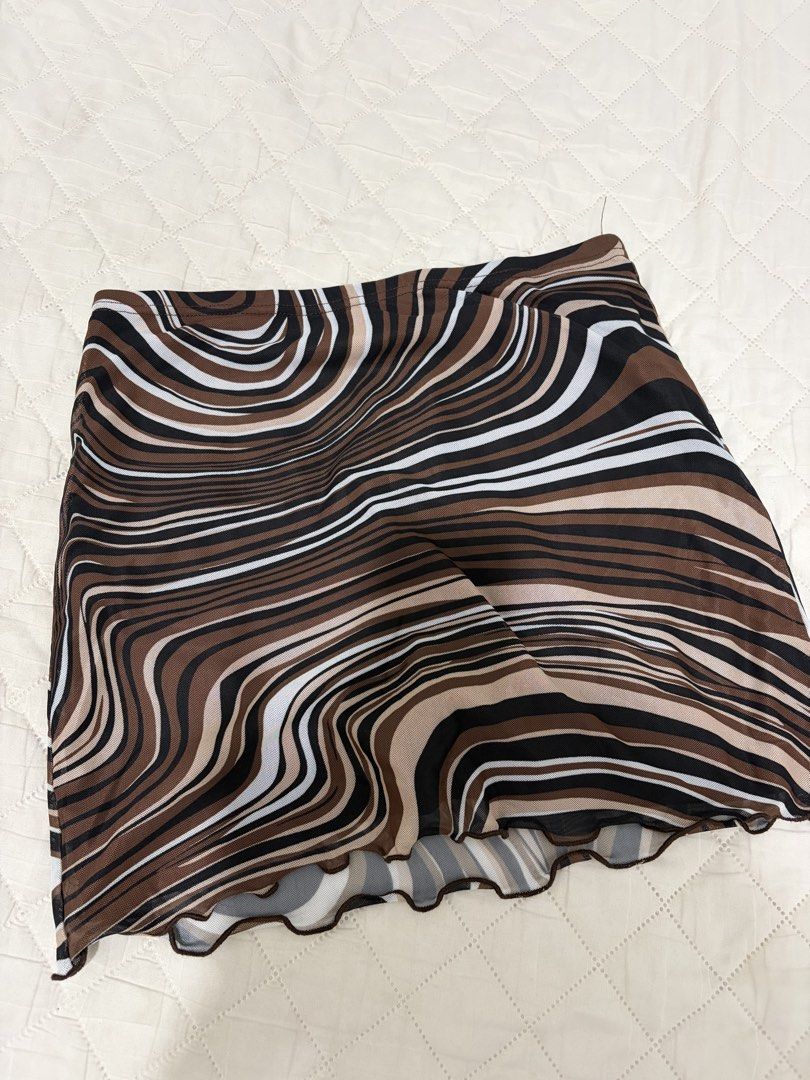 SHEIN Swirl Print Mesh Mini Skirt (Category: Skirts) located in Pateros City. Submitted by dendenden15 (Listing ID 1441505636, Image 1). Description: - Shein brand - Size M - Brown, black, and white swirl print mesh mini skirt - Lettuce hem detail - Lightweight and flowy fabric - Versatile for casual or night out looks.