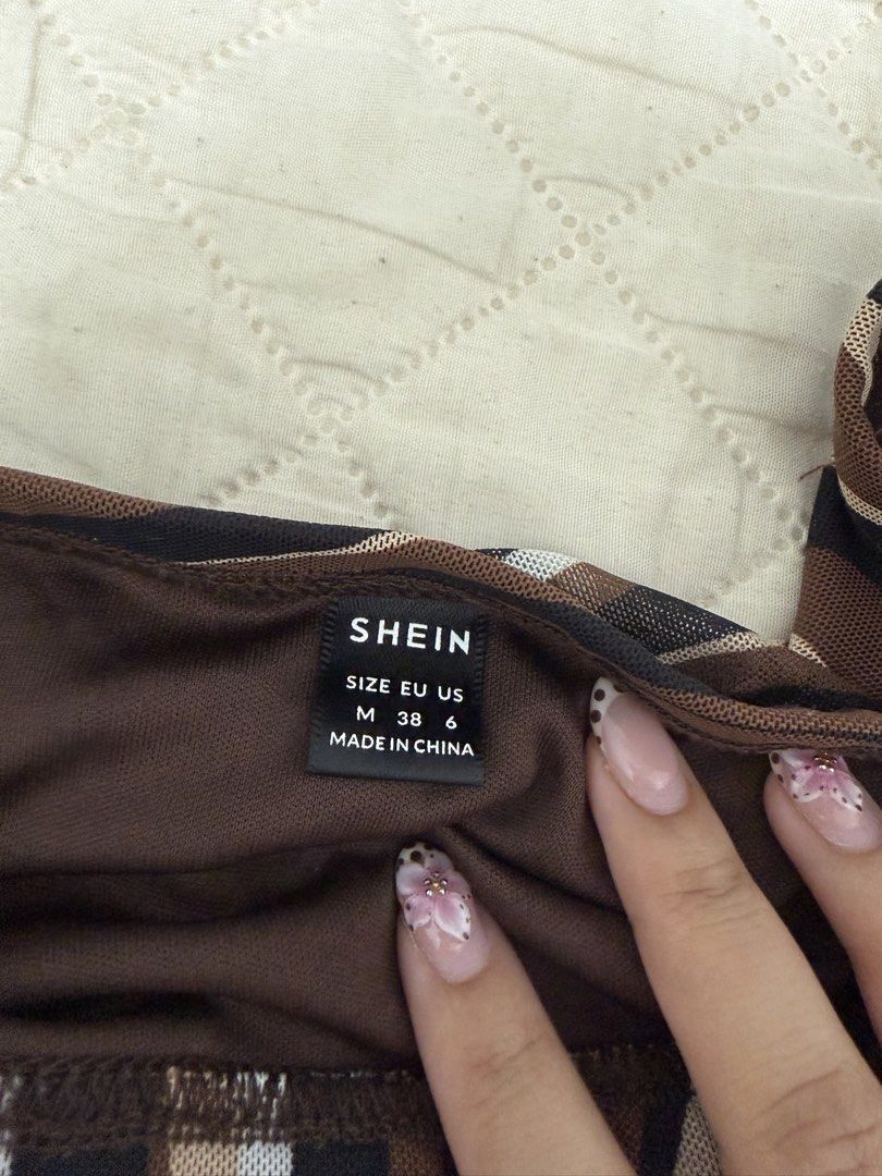SHEIN Swirl Print Mesh Mini Skirt (Category: Skirts) located in Pateros City. Submitted by dendenden15 (Listing ID 1441505636, Image 2). Description: - Shein brand - Size M - Brown, black, and white swirl print mesh mini skirt - Lettuce hem detail - Lightweight and flowy fabric - Versatile for casual or night out looks.