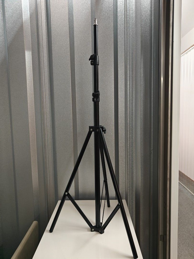 Simple Black Adjustable Tripod Light Stand for Photography Studio (Category: Tripods & Monopods) located in Singapore. Submitted by srarano (Listing ID 1441455691, Image 1). Description: - Adjustable height tripod light stand - Durable black metal construction - Sturdy three-leg base for stability - Folds compactly for easy storage - Standard screw thread on top mount - Perfect for studio lighting and photography equipment - max height 2-2.1m.