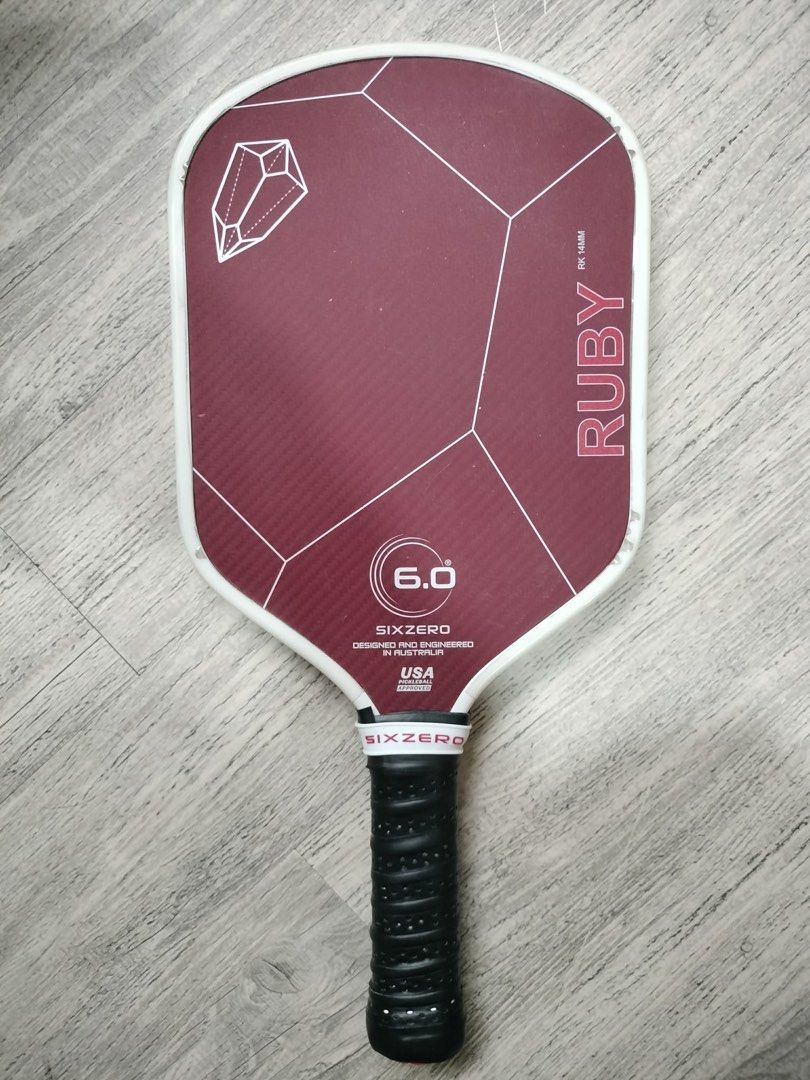 SIXZERO Ruby 6.0 Pickleball Paddle (14mm) (Category: Racket and Ball Sports) located in Quezon City. Submitted by teetharejade (Listing ID 1441472082, Image 1). Description: - SIXZERO Ruby 6.0 pickleball paddle - 14mm - Designed and engineered in the USA - Reliable performance for players - Distinctive maroon surface with geometric patterns - Textured black grip for enhanced handling - no issue to declare, marks seen on the corners are from the e