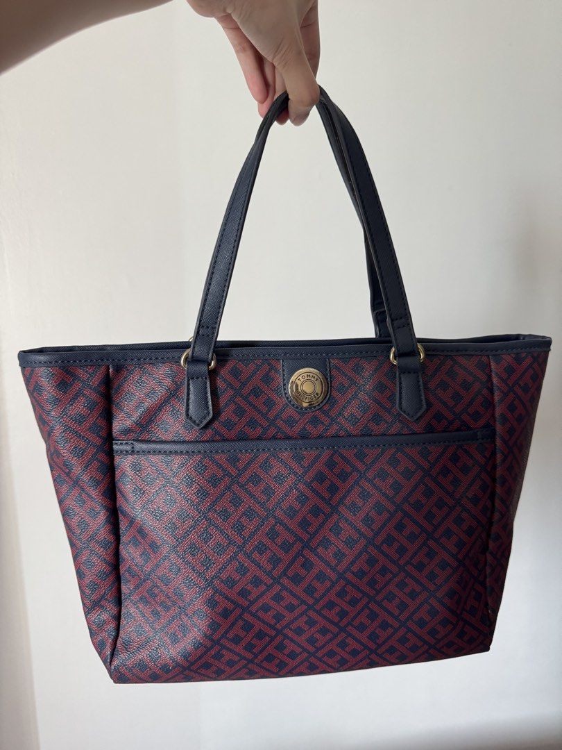 Tommy Hilfiger Monogram Tote Bag (Category: Tote Bags) located in Quezon City. Submitted by nbg.declutter (Listing ID 1441380175, Image 2). Description: - Classic Tommy Hilfiger tote bag - Signature navy and burgundy monogram pattern - Convenient front pocket for easy access - Sturdy top handles for comfortable carrying - Ideal for everyday use -Strap just needs rubber replacement.