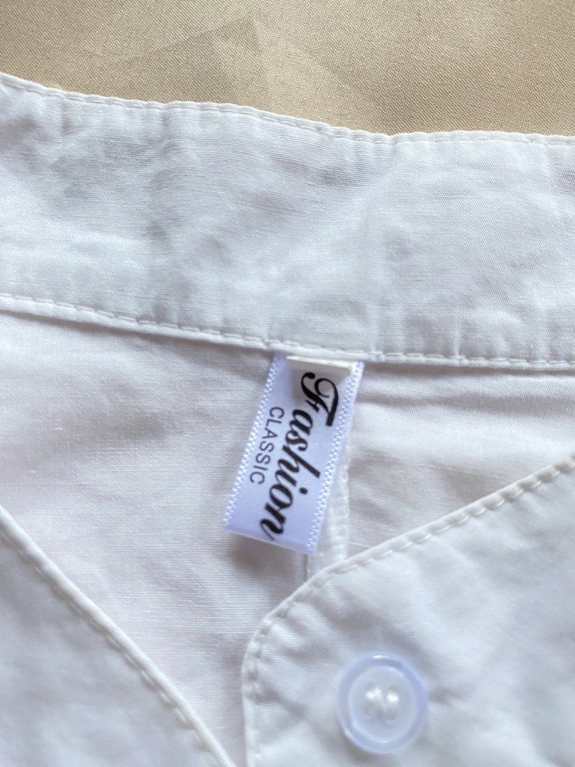 White Mandarin Collar Button Up Shirt with Tie Sides (Category: Blouses) located in Tarlac. Submitted by rieselects (Listing ID 1441464028, Image 2). Description: - Classic white shirt - Mandarin collar - Button-up front - Short, dolman-style sleeves - Adjustable side ties for a custom fit - Can be tied or untied - Simple and versatile.