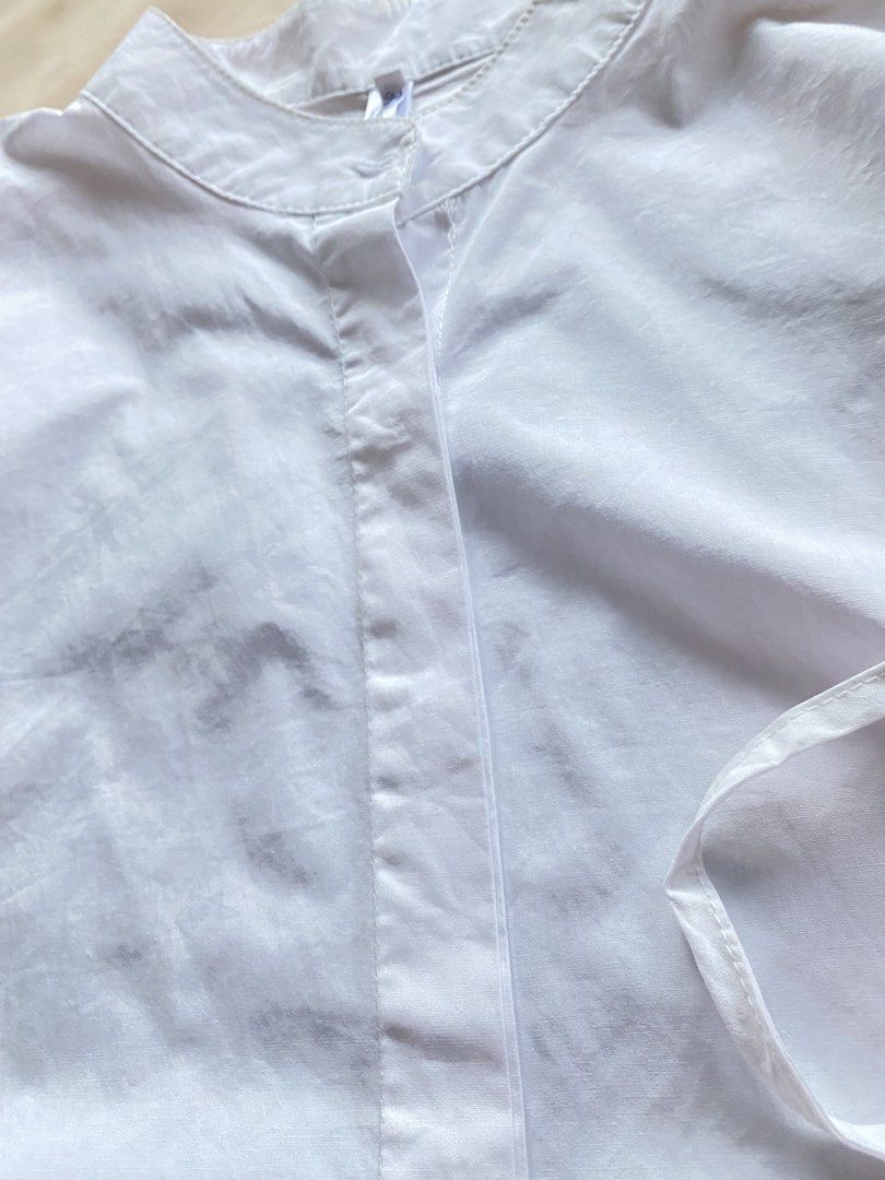 White Mandarin Collar Button Up Shirt with Tie Sides (Category: Blouses) located in Tarlac. Submitted by rieselects (Listing ID 1441464028, Image 3). Description: - Classic white shirt - Mandarin collar - Button-up front - Short, dolman-style sleeves - Adjustable side ties for a custom fit - Can be tied or untied - Simple and versatile.
