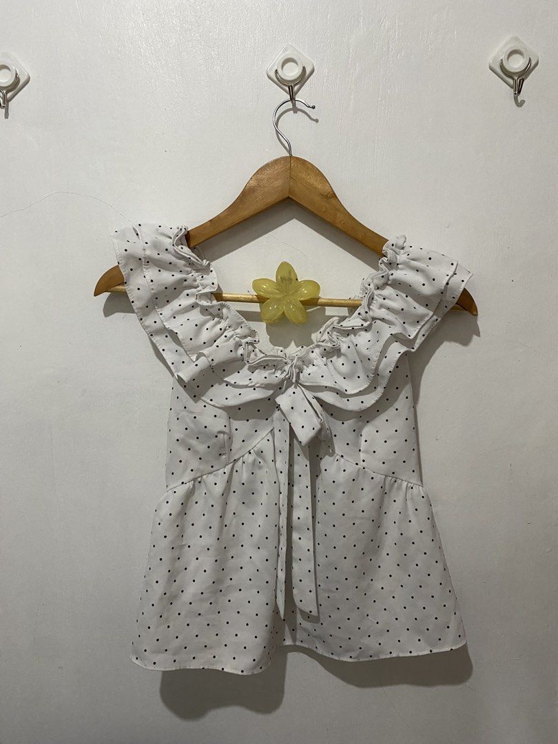 White Polka Dot Off-Shoulder Ruffle Tie Front Top (Category: Blouses) located in Manila. Submitted by carmelana (Listing ID 1441517689, Image 1). Description: - Cute white top with black polka dots - Off-shoulder design with ruffles - Tie front detail - Versatile: pairs well with jeans or skirts - fits small to medium.