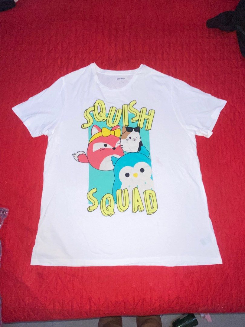 White Squishmallow "Squish Squad" Graphic T-Shirt (Category: Tshirts & Polo Shirts ) located in Manila. Submitted by azumirien (Listing ID 1441544762, Image 1). Description: - Fun 'Squish Squad' graphic on the front - Features adorable cartoon characters - Comfortable and casual design - Ideal for everyday wear.
