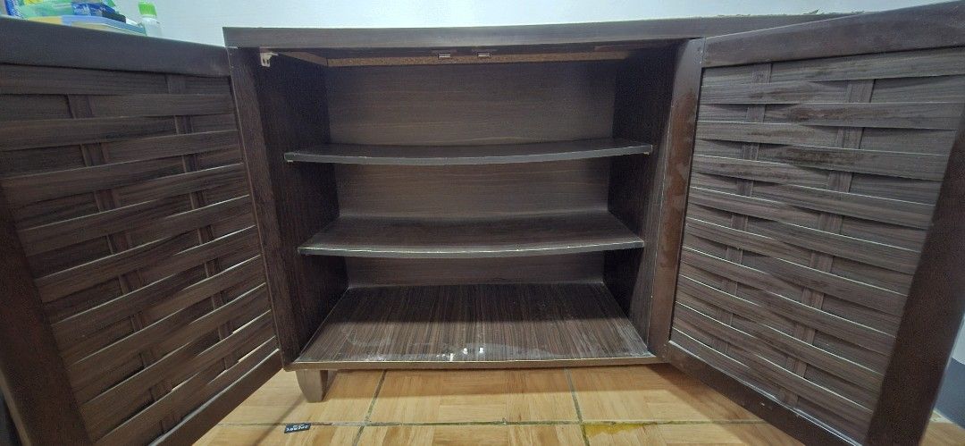 Wooden Cabinet with 3 Doors (Category: Shelves, Cabinets & Racks) located in Imus. Submitted by joyceannespiritu-22966 (Listing ID 1441455749, Image 2). Description: - Stylish dark wood cabinet - Unique woven door design - Three doors open to reveal ample storage shelves - Perfect for organizing your space - Minor scuffs on the bottom, consistent with normal use - Pickup only.