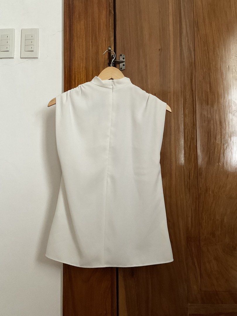 Zara White Mock Neck Sleeveless Top (Category: Sleeveless) located in Iloilo. Submitted by maecha (Listing ID 1441381696, Image 3). Description: - White mock neck sleeveless top from Zara - Features a high neckline and relaxed fit - Subtle seam detail on the back - Effortlessly dress up or down - Pairs perfectly with skirts or trousers.