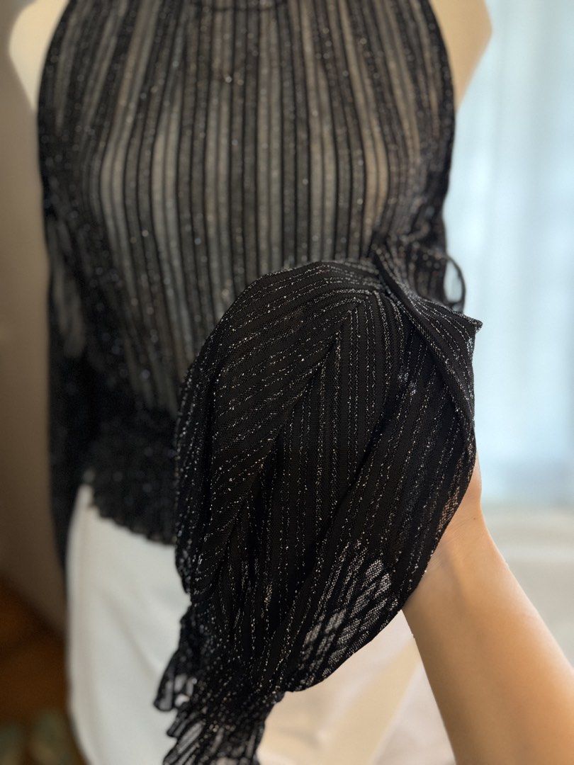Black Sparkly Mesh Cold Shoulder Top with Ruffle Neck (Category: Blouses) located in Quezon City. Submitted by dlm03 (Listing ID 1444905889, Image 3). Description: - Sheer black mesh fabric with vertical stripes and subtle sparkle - High ruffled neckline - Cold shoulder design - Long sleeves with ruffled cuffs - Smocked elastic waistband - Versatile for night outs or layering - Pairs well with jeans or skirts - Fits M-L .