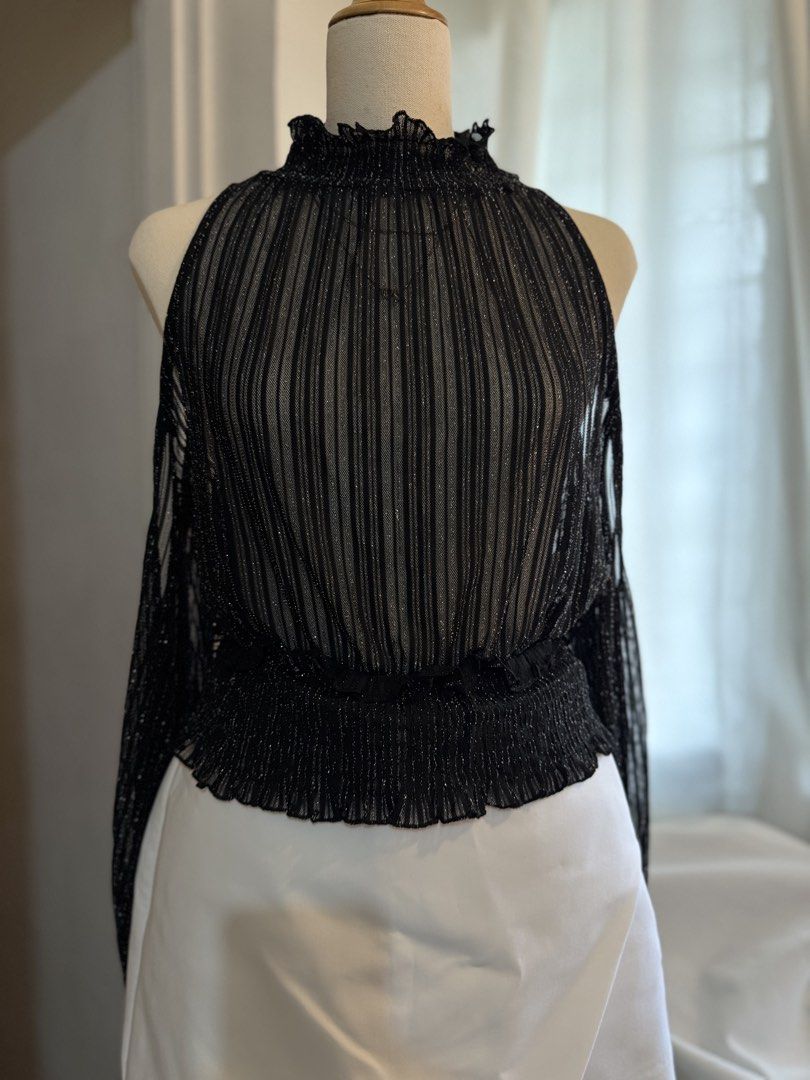 Black Sparkly Mesh Cold Shoulder Top with Ruffle Neck (Category: Blouses) located in Quezon City. Submitted by dlm03 (Listing ID 1444905889, Image 2). Description: - Sheer black mesh fabric with vertical stripes and subtle sparkle - High ruffled neckline - Cold shoulder design - Long sleeves with ruffled cuffs - Smocked elastic waistband - Versatile for night outs or layering - Pairs well with jeans or skirts - Fits M-L .