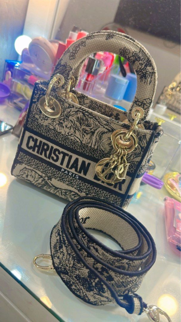 Christian Dior Lady Dior Mini D-Lite (Category: Luxury Bags & Wallets) located in Paranaque City. Submitted by Barrbiee (Listing ID 1444984315, Image 2). Description: - Authentic Christian Dior Mini Lady Dior D-lite Bag -Lightly used -with entrupy - Unique animal print design - Features 'Christian Dior Paris' lettering - Comes with a detachable strap for versatile wear - Elegant gold-tone hardware and charms - Ideal as a standout statement piece.