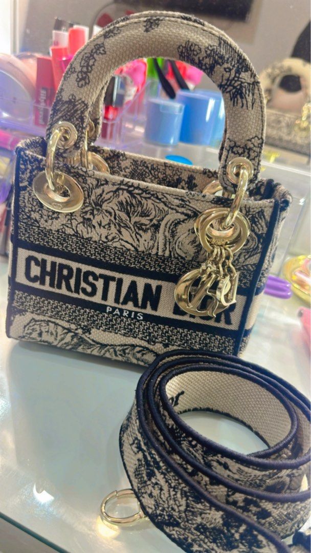 Christian Dior Lady Dior Mini D-Lite (Category: Luxury Bags & Wallets) located in Paranaque City. Submitted by Barrbiee (Listing ID 1444984315, Image 3). Description: - Authentic Christian Dior Mini Lady Dior D-lite Bag -Lightly used -with entrupy - Unique animal print design - Features 'Christian Dior Paris' lettering - Comes with a detachable strap for versatile wear - Elegant gold-tone hardware and charms - Ideal as a standout statement piece.