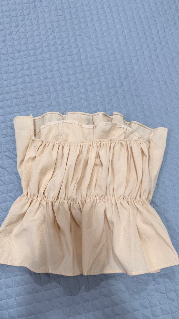 Cream Ruffle Strapless Tube Top Peplum (Category: Others Tops) located in Manila. Submitted by ria_25 (Listing ID 1444907792, Image 2). Description: - Cream colored strapless tube top - Ruffle detail along top and bottom hem - Peplum style - Estimated size: Small to Medium - Versatile for night out or casual wear - Pairs well with jeans or skirts (Worn once) .