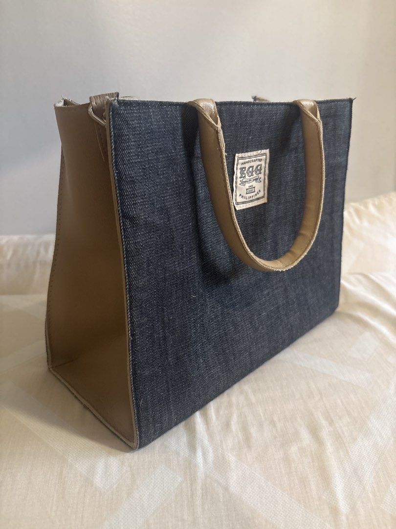EGG Denim Tote Bag w strap (Category: Tote Bags) located in Manila. Submitted by esstarita (Listing ID 1444934634, Image 2). Description: - Chic denim tote bag - Accented with tan leather details - Features a small logo patch on the front - Tan leather handles - Structured, classic shape - Ideal for everyday carry - Proudly made in the Philippines.