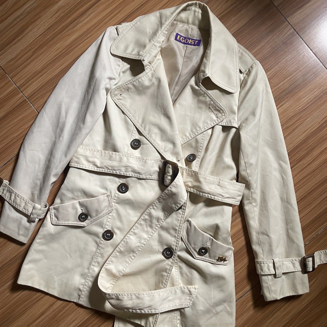 Egoist Beige Trench Coat (Category: Coats, Jackets and Outerwear) located in General Mariano Alvarez. Submitted by 4117_thriftnthrive (Listing ID 1444918614, Image 2). Description: In excellent condition No flaws Size: Measurements Width: 16” Length: 27.5”.