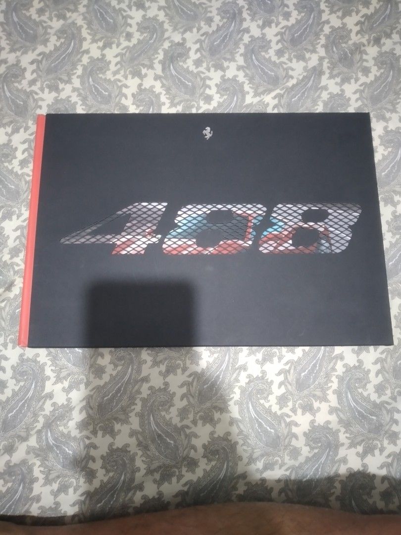 Ferrari 488 GTB Hardcover Brochure (Category: Vintage Collectibles) located in Pasig City. Submitted by aecollection03 (Listing ID 1444980811, Image 1). Description: - Ferrari 488 GTB brochure - Comes with a protective black sleeve - Sleeve has the model name embossed - Brochure features a stunning image of the 488 GTB on a winding road - Back cover is solid red - Ideal collectible for Ferrari enthusiasts -small fold and scratch on pages 1&2 (bac