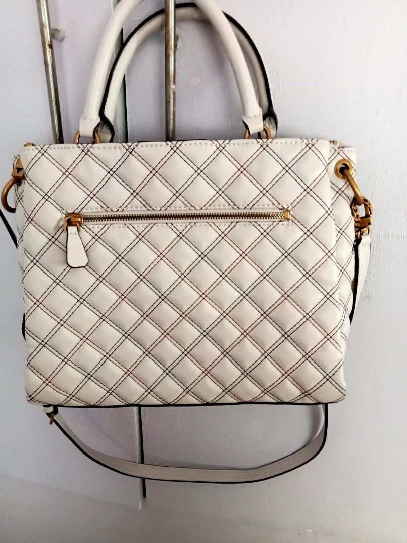 Guess White Quilted Handbag with Shoulder Strap (Category: Shoulder Bags) located in Santa Rosa. Submitted by vverb09 (Listing ID 1444913137, Image 2). Description: - Stylish Guess handbag - Elegant quilted pattern - Eye-catching red and blue contrast stitching - Versatile with top handles and a detachable shoulder strap - Premium gold-tone hardware - Convenient zippered pocket on the back - Includes original Guess keychain tag - Ideal for everyd