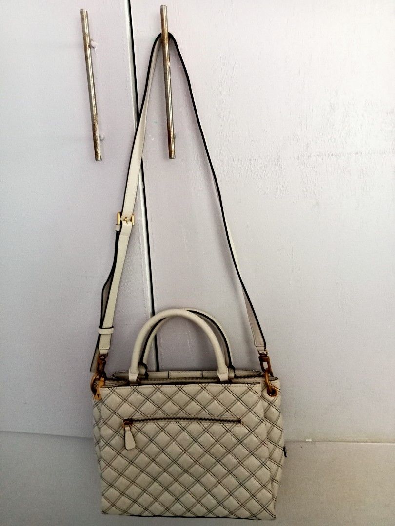 Guess White Quilted Handbag with Shoulder Strap (Category: Shoulder Bags) located in Santa Rosa. Submitted by vverb09 (Listing ID 1444913137, Image 3). Description: - Stylish Guess handbag - Elegant quilted pattern - Eye-catching red and blue contrast stitching - Versatile with top handles and a detachable shoulder strap - Premium gold-tone hardware - Convenient zippered pocket on the back - Includes original Guess keychain tag - Ideal for everyd
