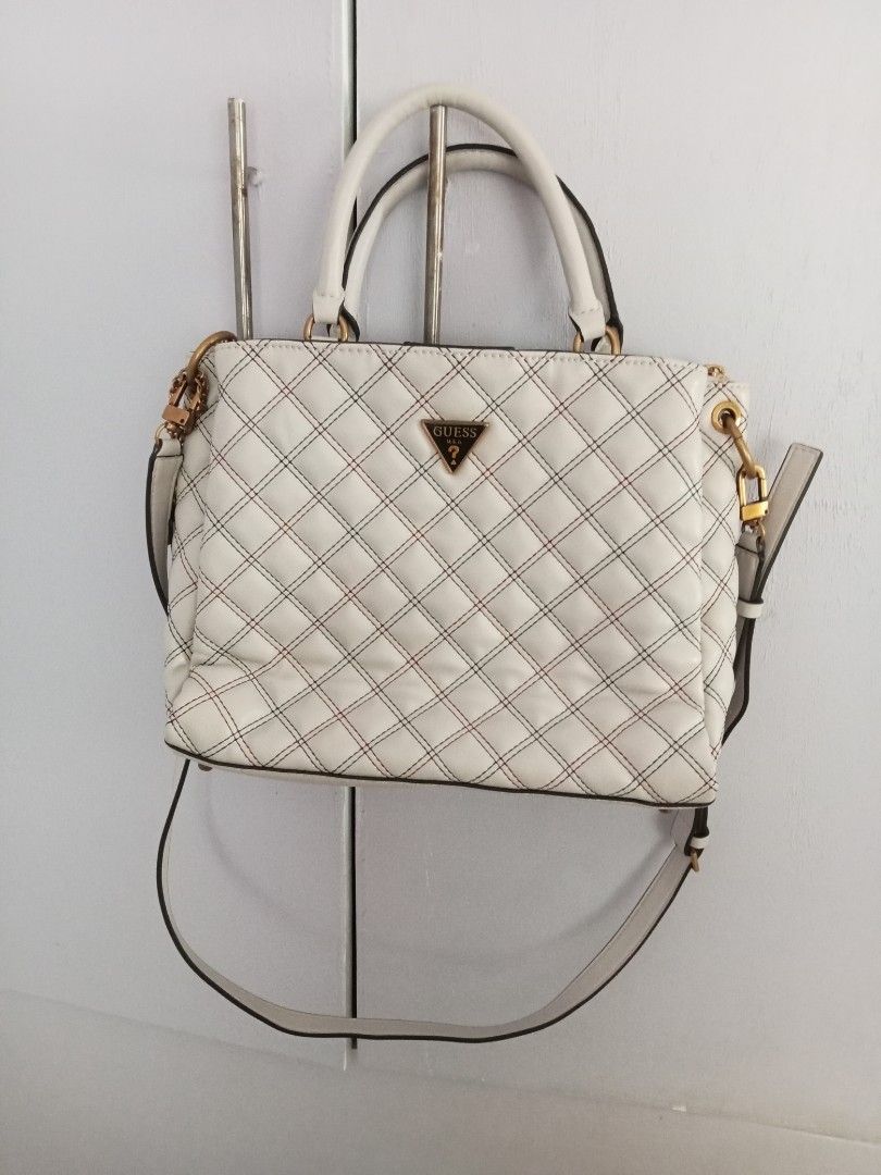 Guess White Quilted Handbag with Shoulder Strap (Category: Shoulder Bags) located in Santa Rosa. Submitted by vverb09 (Listing ID 1444913137, Image 1). Description: - Stylish Guess handbag - Elegant quilted pattern - Eye-catching red and blue contrast stitching - Versatile with top handles and a detachable shoulder strap - Premium gold-tone hardware - Convenient zippered pocket on the back - Includes original Guess keychain tag - Ideal for everyd