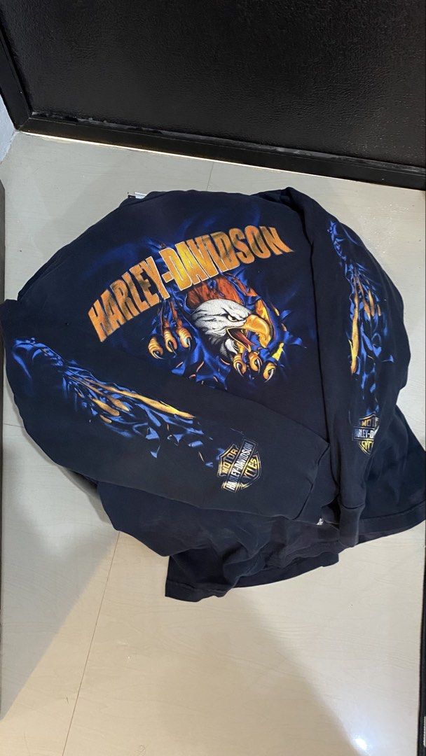 Harley-Davidson Long Sleeve T-Shirt Eagle Graphic (Category: Tshirts & Polo Shirts ) located in Porac. Submitted by moethrifter (Listing ID 1444948407, Image 2). Description: - Navy blue long sleeve t-shirt - Ripped effect graphic on front: eagle and flames - Back text: 'Barnes Harley-Davidson Langley, BC Canada' - Comfortable cotton material - Perfect for Harley-Davidson fans.