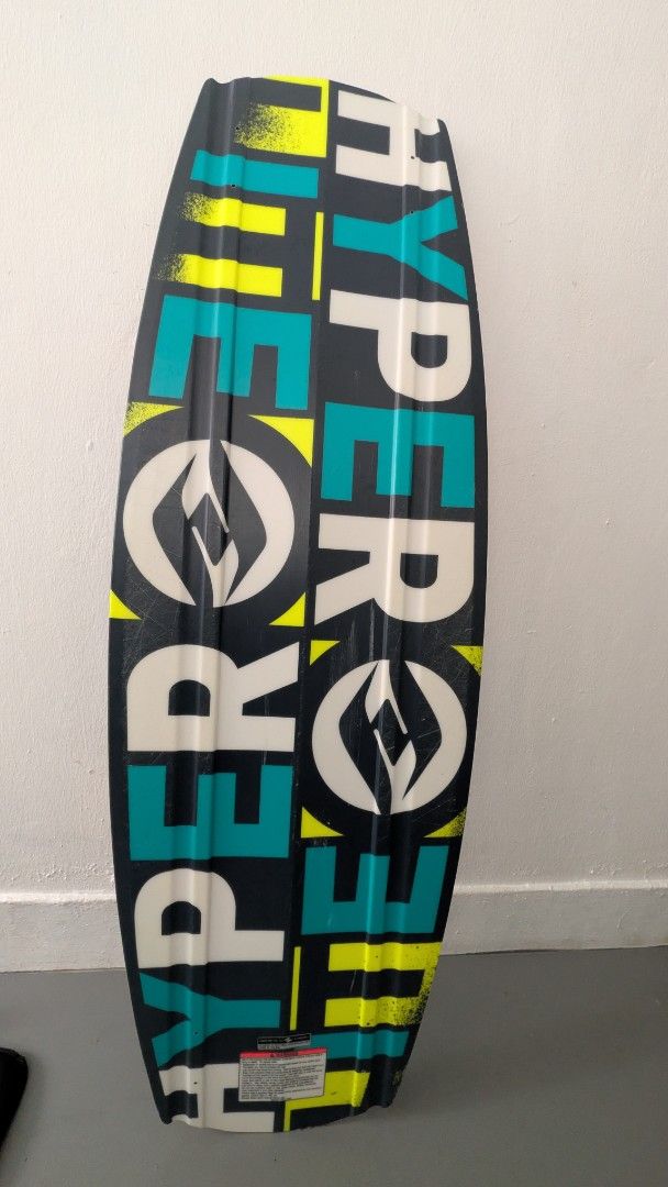 Hyperlite Wakeboard (Category: Water Sports) located in Singapore. Submitted by mixednut (Listing ID 1444972748, Image 2). Description: - Used Hyperlite wakeboard - Color: Black with teal and yellow accents - Condition: Shows scuffs and chips on edges from use, but still has plenty of life left - Features: Stickers on the bottom - Ready for immediate use on the water.