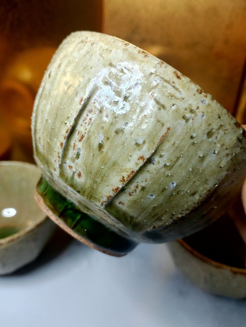 Japanese Ceramic Tea Cups with Green Glaze (Category: Coffee & Tea Tableware) located in Valenzuela. Submitted by buylaaaaa (Listing ID 1444934198, Image 3). Description: - Set of 5 beautiful ceramic tea cups. - Each cup features a unique green glaze at the bottom. - Rustic, textured exterior with subtle vertical lines. - Stackable design for convenient storage. - Perfect for enjoying your favorite tea. - Handcrafted aesthetic..