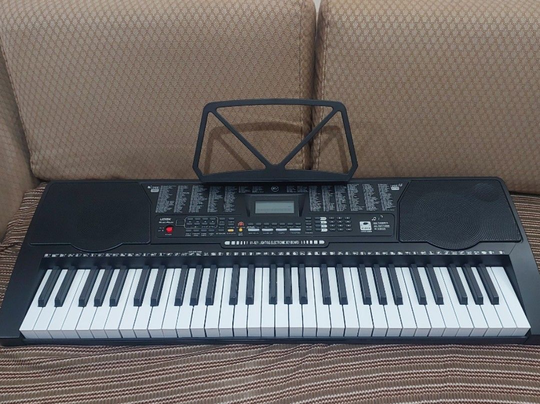 K-7700 Electronic Keyboard (Category: Computer Keyboard) located in Makati City. Submitted by grande.taille.by.ab (Listing ID 1438389965, Image 1). Description: - Electronic keyboard with built-in music stand - Features a display screen and function buttons - Full set of white and black keys - Built-in speakers - Model number visible.