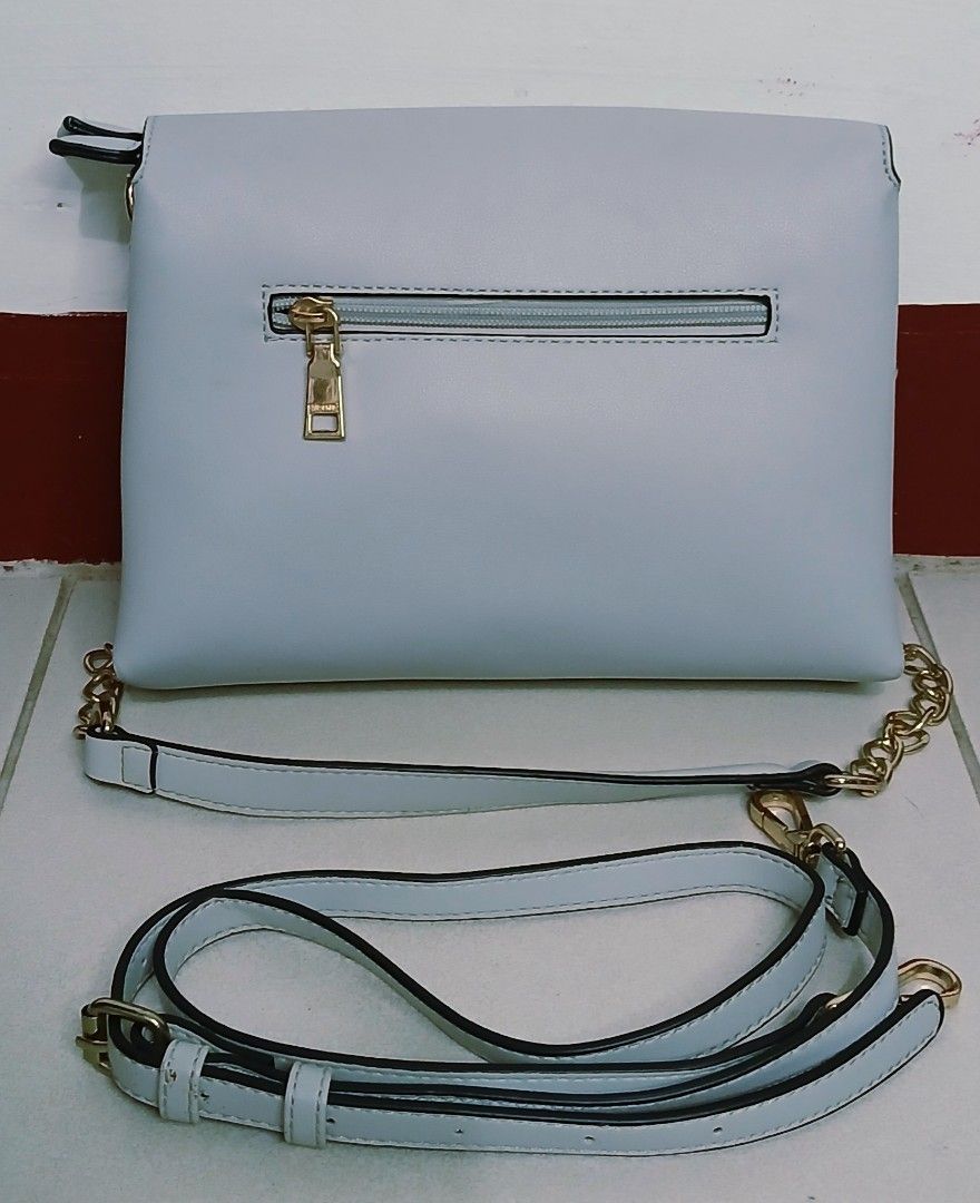 Light Blue Crossbody Bag with Gold Chain Strap (Category: Cross-body Bags) located in Las Pinas. Submitted by anna_katrina (Listing ID 1445032492, Image 2). Description: - Light blue crossbody bag - Elegant gold chain strap - Includes a detachable longer strap for versatility - Multiple compartments inside for organization - Convenient zippered pocket on the back exterior - Clean and simple aesthetic.