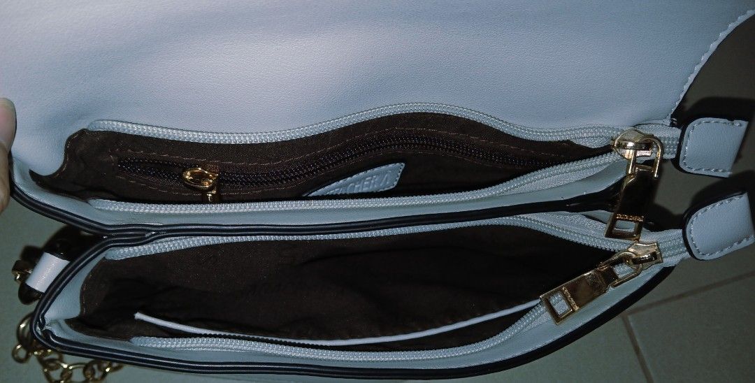 Light Blue Crossbody Bag with Gold Chain Strap (Category: Cross-body Bags) located in Las Pinas. Submitted by anna_katrina (Listing ID 1445032492, Image 3). Description: - Light blue crossbody bag - Elegant gold chain strap - Includes a detachable longer strap for versatility - Multiple compartments inside for organization - Convenient zippered pocket on the back exterior - Clean and simple aesthetic.
