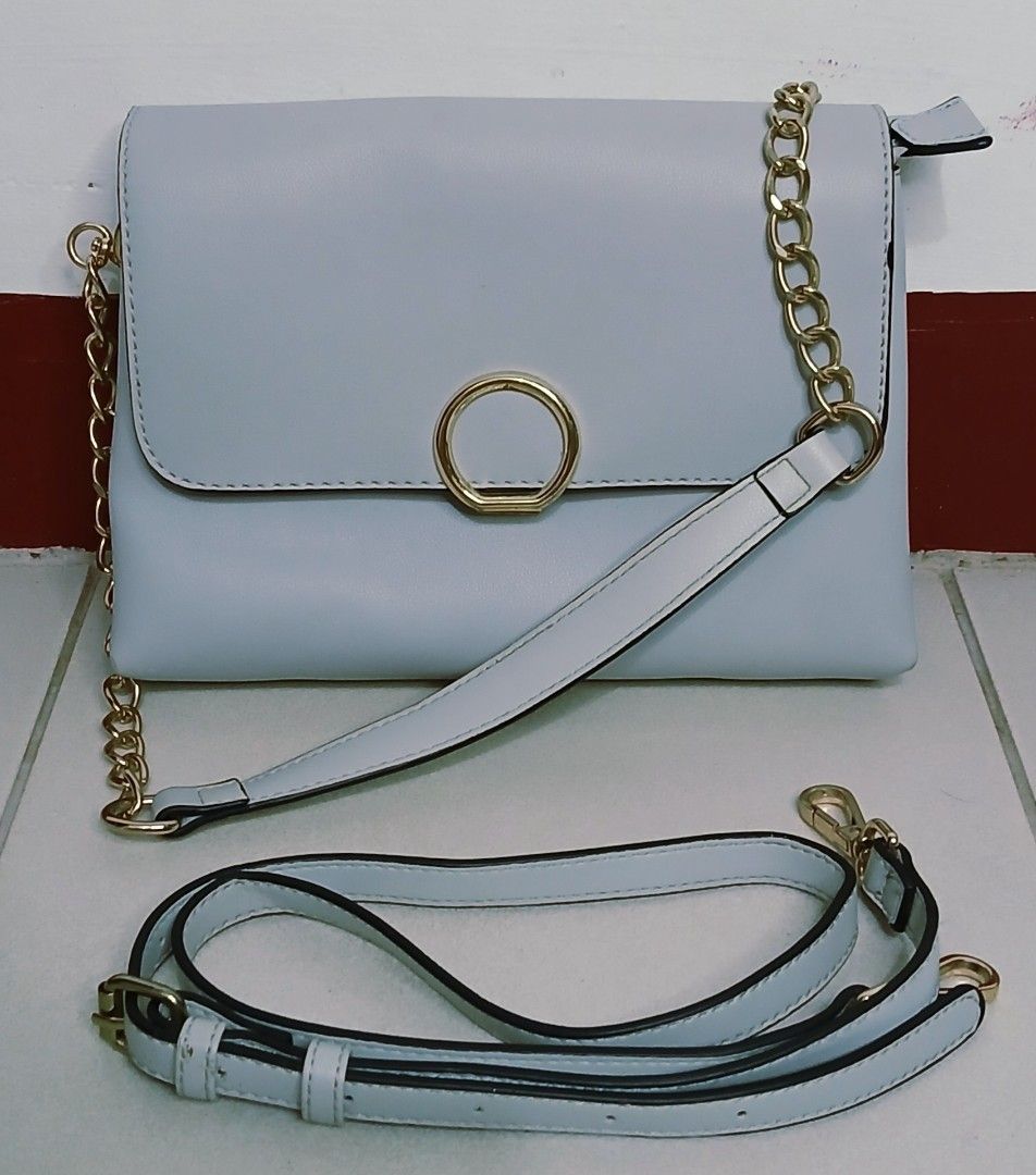 Light Blue Crossbody Bag with Gold Chain Strap (Category: Cross-body Bags) located in Las Pinas. Submitted by anna_katrina (Listing ID 1445032492, Image 1). Description: - Light blue crossbody bag - Elegant gold chain strap - Includes a detachable longer strap for versatility - Multiple compartments inside for organization - Convenient zippered pocket on the back exterior - Clean and simple aesthetic.