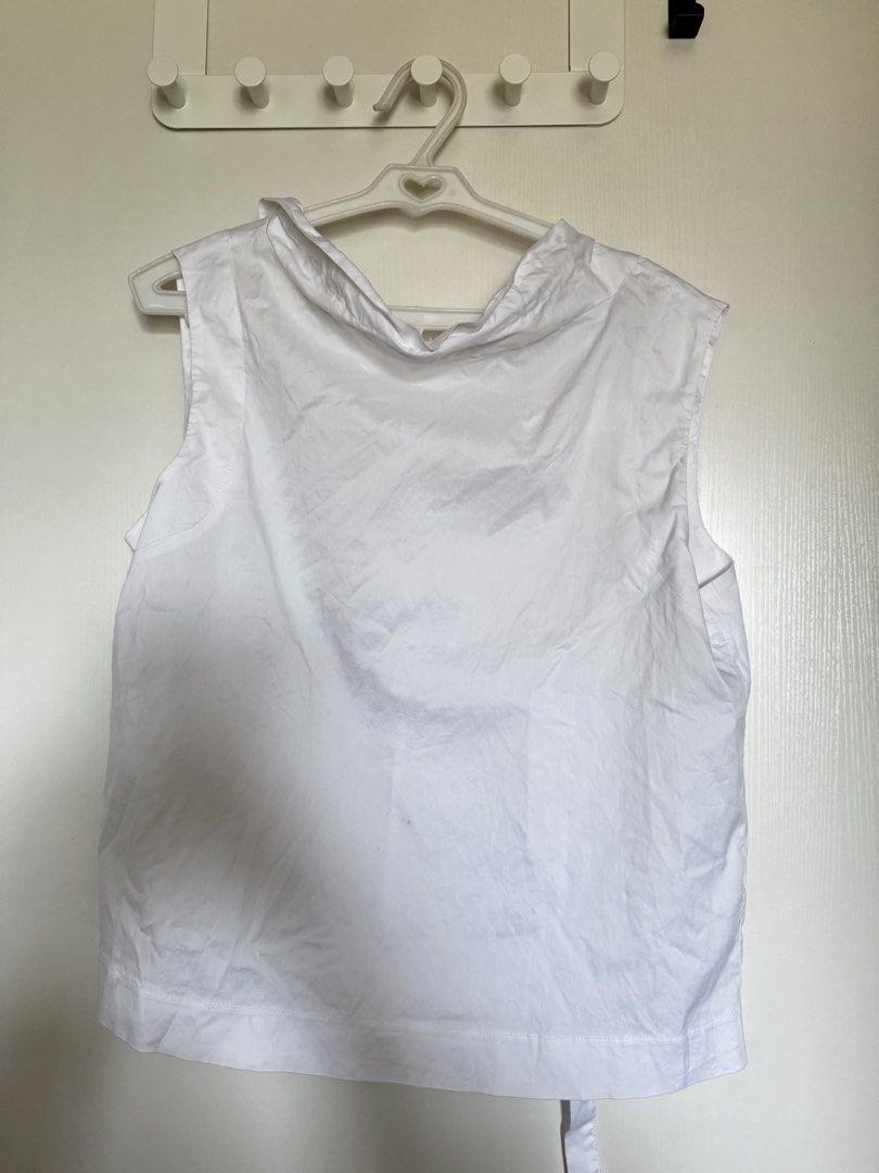 Mosaic White Sleeveless Top with High Neck (Category: Sleeveless) located in Muntinlupa City. Submitted by gclosetcleanup (Listing ID 1445005274, Image 1). Description: - White sleeveless top - High neckline with gathered detail - Simple and clean design - Features a tie at the back - Versatile for layering or wearing on its own - Easy to pair with any outfit.