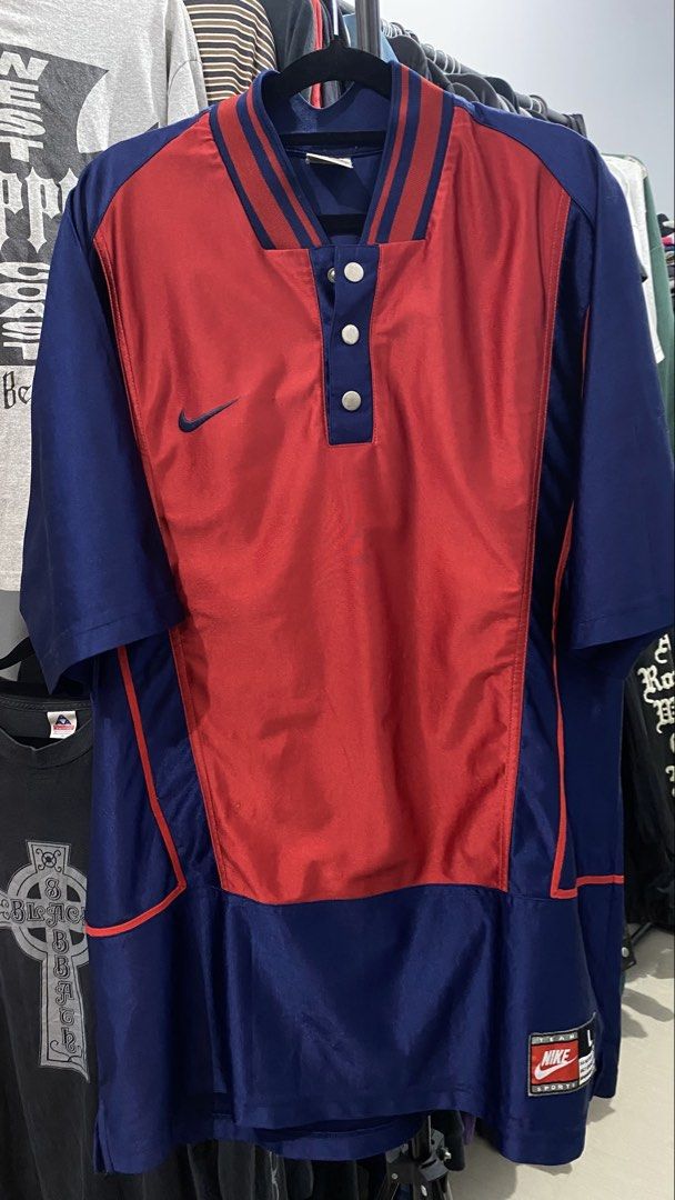 Nike Baseball Jacket Red Blue Snap Button (Category: Coats, Jackets and Outerwear) located in Porac. Submitted by moethrifter (Listing ID 1444949615, Image 1). Description: - Vintage Nike Jacket - Color: Red and Navy Blue - Size: L - Short sleeves - Snap button closure at the neck - Striped detailing on the collar - Nike swoosh logo on the chest - Perfect for collectors.