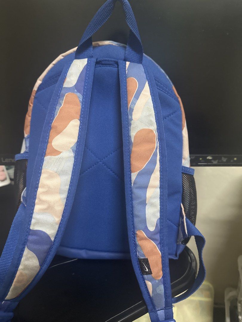 Nike Camo Backpack (Category: Babies & Kids Fashion) located in Mandaluyong City. Submitted by belowp99 (Listing ID 1444953636, Image 2). Description: - Cute Nike backpack with a stylish camouflage pattern. - Features blue, tan, and white colors. - Includes a convenient front zip pocket and side mesh pockets. - Adjustable straps for a comfortable fit. - Ideal for school, sports, or everyday adventures. - Comes with the original 'Just Do It' tag a